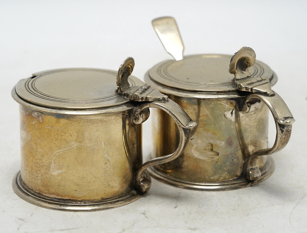 A pair of George V silver drum mustards, by Harman & Co, London 1929, 70mm, one with associated spoon. Condition - fair